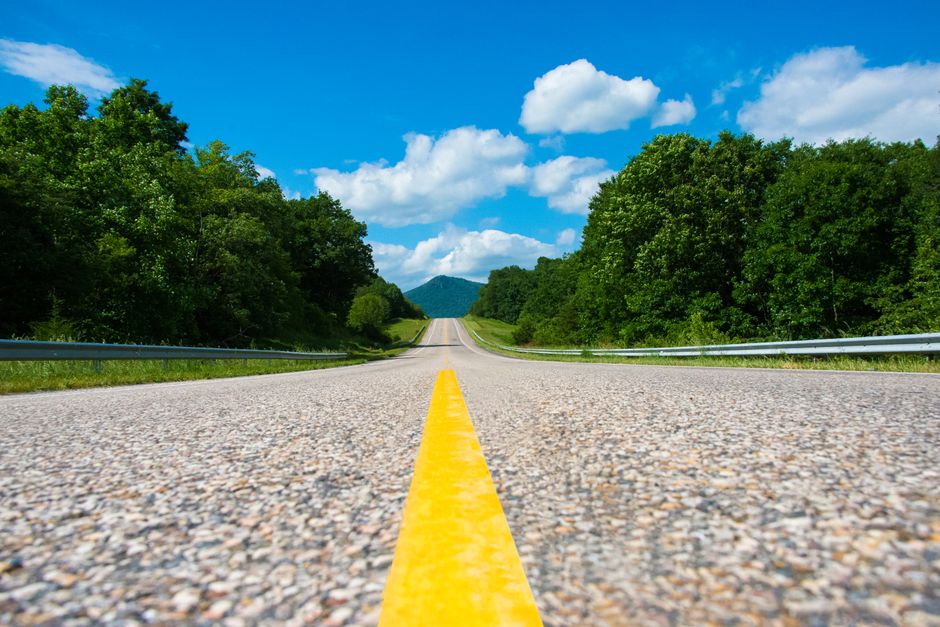 A scenic highway stretches into the horizon under a bright blue sky in Virginia, USA.
